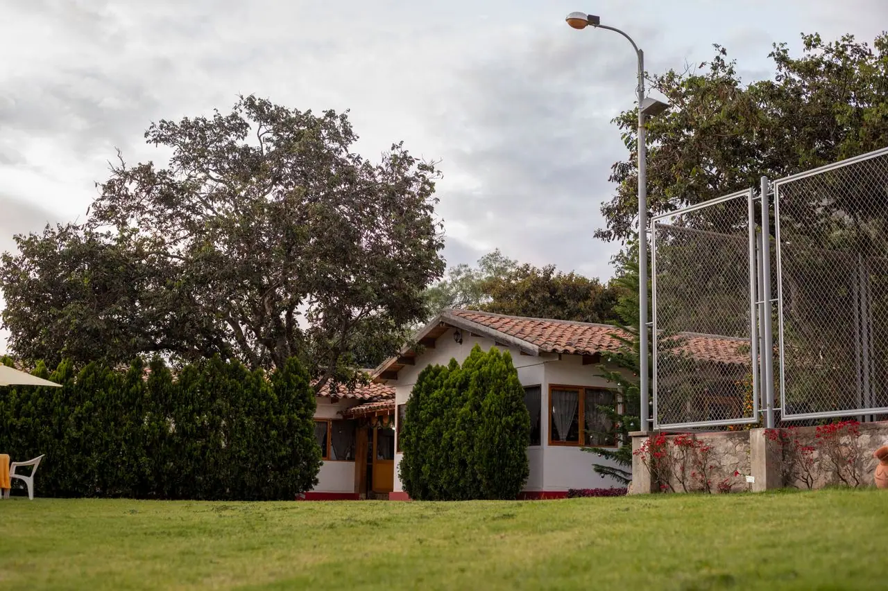 Bungalow de teja junto a amplios jardines y cancha deportiva