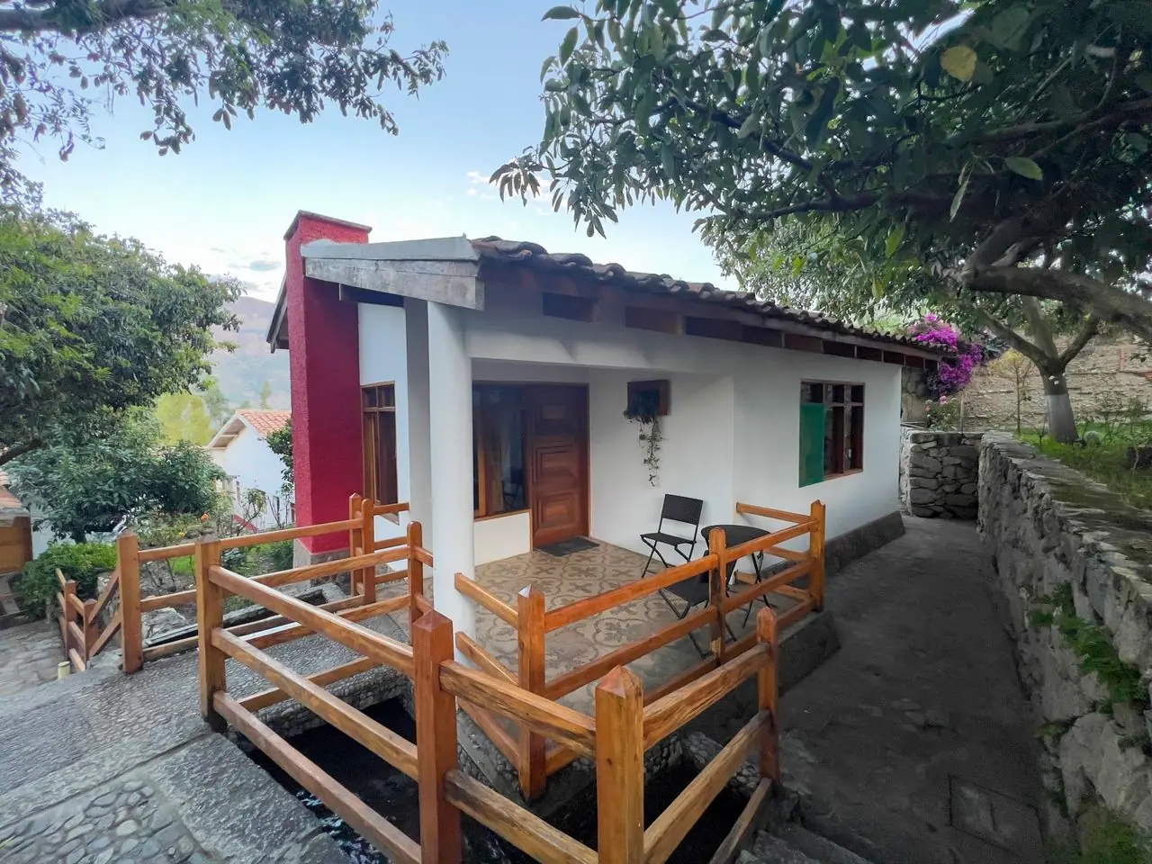 Terraza de madera de una cabaña con vista al jardín